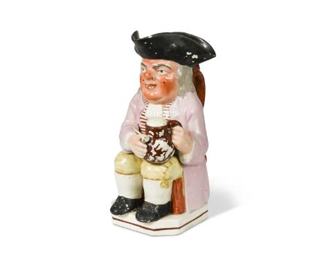 seated, holding a foaming jug of ale and a pipe, wearing a lilac coat and yellow breeches, on a canted base, 24cm highFootnot