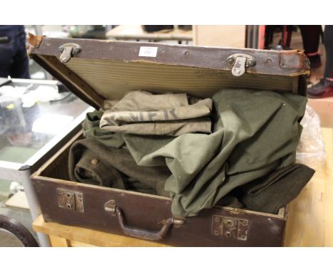 A VINTAGE LEATHER SUITCASE CONTAINING ARMY CLOTHING, CANVAS BAGS ETC 