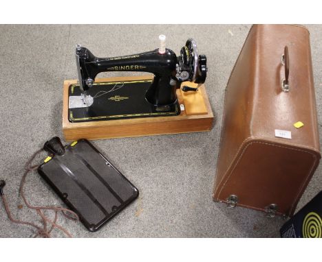 A CASED VINTAGE SINGER SEWING MACHINE MODEL NUMBER F6499668 TOGETHER WITH A VINTAGE BAKELITE ELECTRIC HOT WATER BOTTLE (COLLE