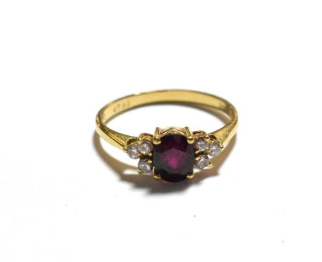 A ruby and diamond ring, stamped '750', finger size J1/2.  Gross weight 2.31 grams. 