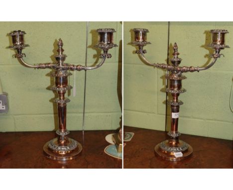 A pair of silver-plated two-light candelabra, 19th century, each on circular base with foliage band, the tapering stem with c