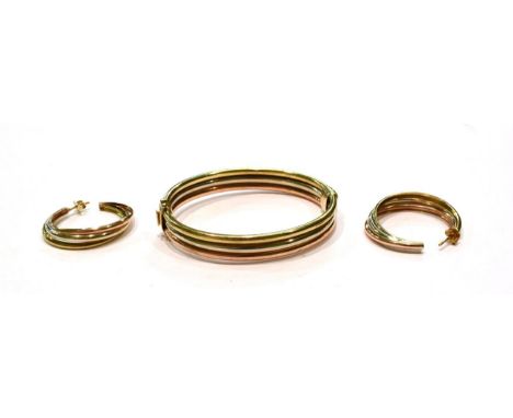 A 9 carat gold tri-colour bangle; and a pair of similar earrings, unmarked  .  Bangle - 22.6 grams. Earrings - 8.3 grams. 