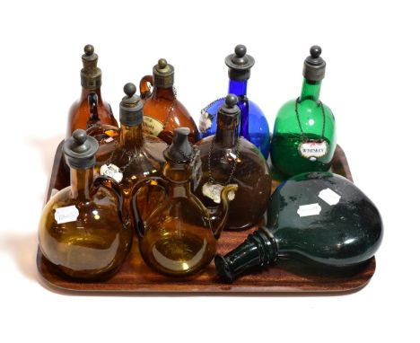 An 18th century green glass flask, 23cm height; together with eight various coloured spirit flasks with stoppers; some enamel