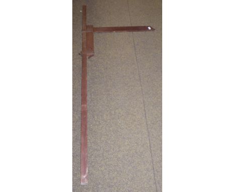 A brown stained wood horse measuring stick with lead plumb bob