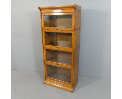 An early 20th century oak Globe Wernicke style four shelf sectional stacking bookcase. Width 66cm, height 157cm, depth 36cm.N