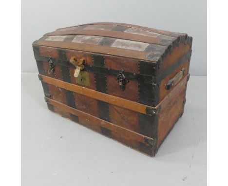 A Victorian leather covered dome-top trunk with tooled and embossed decoration. Width 82cm, height 60cm, depth 37cm.