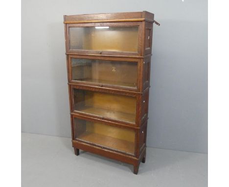 MACEY - An early 20th century oak four shelf sectional stacking bookcase, with glazed doors and maker's labels. Width 88cm, h