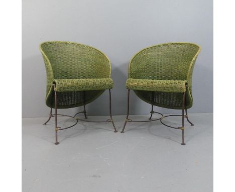 A pair of vintage wicker conservatory chairs with wrought metal base and x-shaped stretcher.