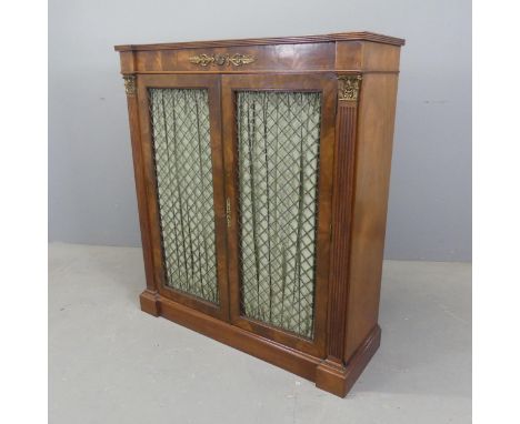 A Regency cross-banded flamed mahogany chiffonier, with two lattice brass panelled doors, brass mounts and carved fluted deco