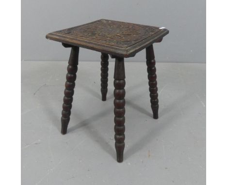 An Arts &amp; Crafts style oak stool, with carved decoration and bobbin turned legs. Width 31cm, height 41cm.