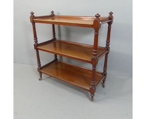 A Victorian mahogany three-tier buffet, raised on brass casters. W107cm, H117cm, D48cm.
