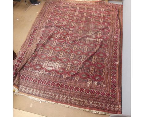 A red-ground Turkmen carpet. Length 355cm, width 280cm.