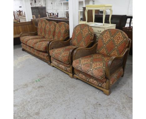 A 1930s Art Deco walnut framed three-piece Bergere lounge suite, comprising a sofa and two matching armchairs.Sofa dimensions