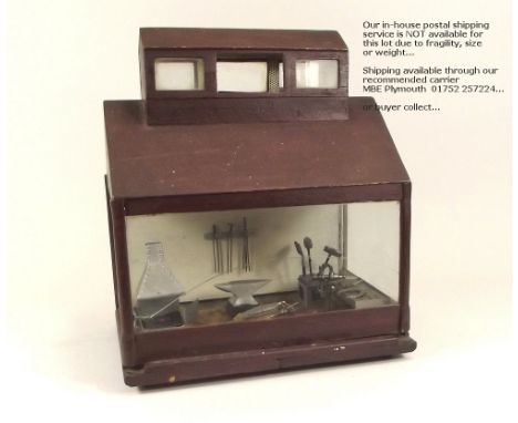 MODEL BLACKSMITH'S SHOP.A late 19th/early 20th century model blacksmith shop with various miniature tools etc., glazed archit