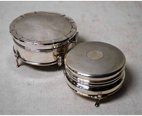 An early 20th century silver hinged lidded box of compressed circular form, three-footed, engine turned lid,f 3.39oz gross, B