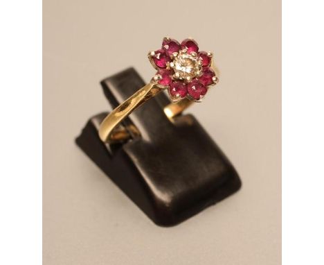 A RUBY AND DIAMOND CLUSTER RING, the brilliant cut diamond claw set to a border of eight small rubies, to a plain 18ct gold s