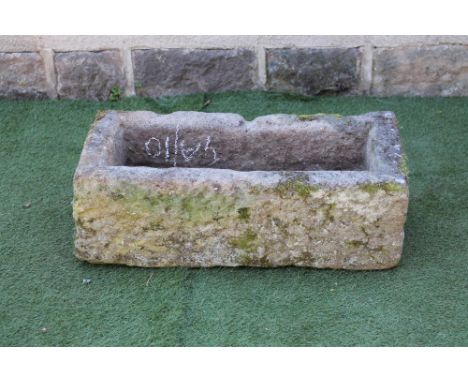 A SANDSTONE TROUGH of rough hewn oblong form, 34" x 17 1/2" x 11 1/2" (Est. plus 21% premium inc. VAT)