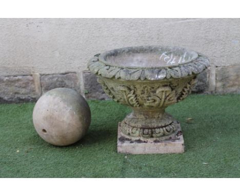 A COMPOSITION STONE URN, the stiff leaf moulded bowl on turned socle with ovolu banding and square base, 24" x 18 1/2", toget