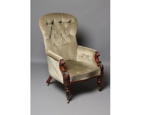 AN EARLY VICTORIAN MAHOGANY FRAMED ARMCHAIR button upholstered in pale green dralon, arched padded back, scroll and leaf carv