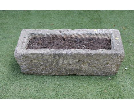 A SANDSTONE TROUGH of shallow oblong form with mildly tapering rusticated sides, 26 1/2" x 12 1/2" x 7 1/2" (Est. plus 21% pr