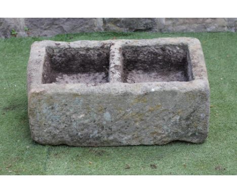 A SANDSTONE TROUGH of well cut oblong form, with central division and mildly sloping top, 32 1/2" x 17" x 12 1/2" (Est. plus 
