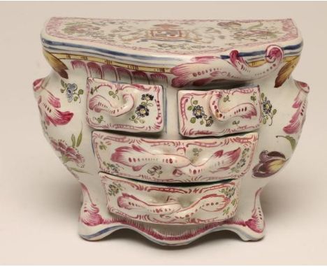 A STRASBOURG FAIENCE COMMODE, late 19th century, of bombe serpentine form, the top painted in polychrome enamels with an armo