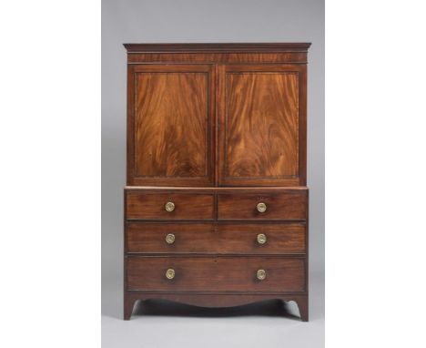 A REGENCY MAHOGANY LINEN PRESS, the cavetto moulded cornice and plain frieze over two panelled doors with ebony stringing and