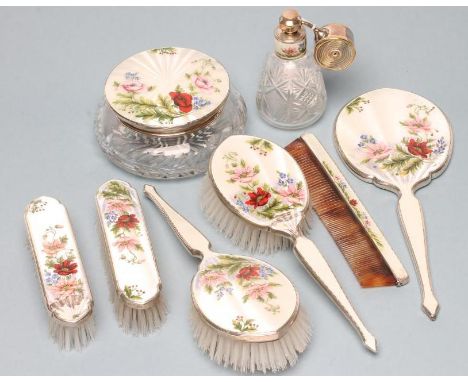 AN EIGHT PIECE SILVER DRESSING TABLE SET, Birmingham 1959/60/67, the white guilloche enamel painted in colours with flowers a