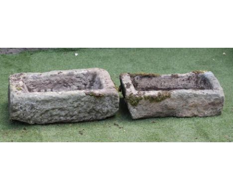 A SMALL SANDSTONE TROUGH of rough hewn oblong form, 25" x 14" x 8 1/2", together with another similar, 29 1/2" x 11 1/2" x 6"