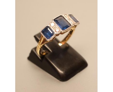 AN ART DECO STYLE SAPPHIRE AND DIAMOND HALF HOOP RING, the three oblong facet cut collet set sapphires with four diamond poin