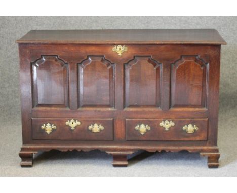 AN OAK PANELLED CHEST, mid/late 18th century, the moulded edged plank lid opening to interior with till box, the fascia with 