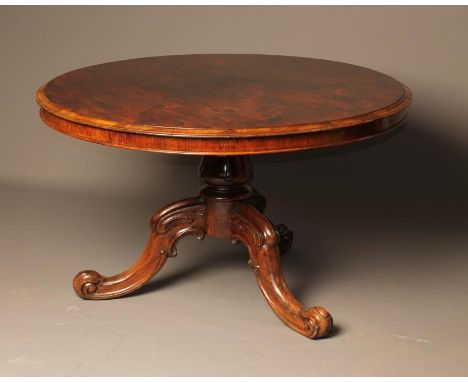 A VICTORIAN ROSEWOOD CENTRE TABLE of circular form, the moulded edged tip up top on lotus carved support, on tripod base with