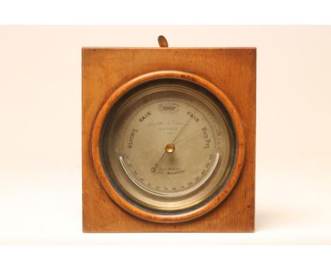 A BRASS CASED ANEROID BAROMETER by Negretti &amp; Zambra, London, the silvered dial with semi-circular thermometer, in origin