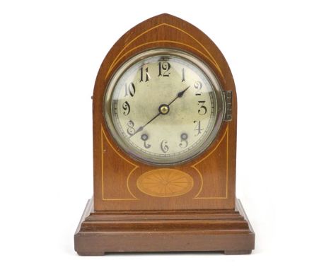 An Edwardian mahogany and line inlaid mantle clock, the silvered dial with scrolling Arabic numerals in an arching case with 