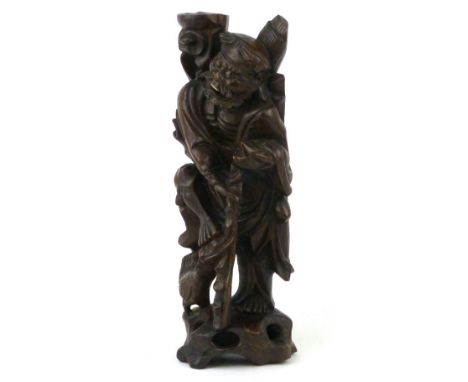 A Chinese root wood carving of a man holding a walking stick, chicken at his feet with inset eyes and teeth h. 35cm CONDITION