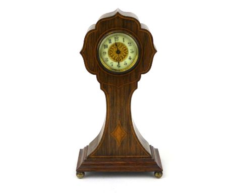 An Edwardian rosewood mantle clock with ivorine and brass dial, line inlaid and patera decoration raised on brass ball feet. 