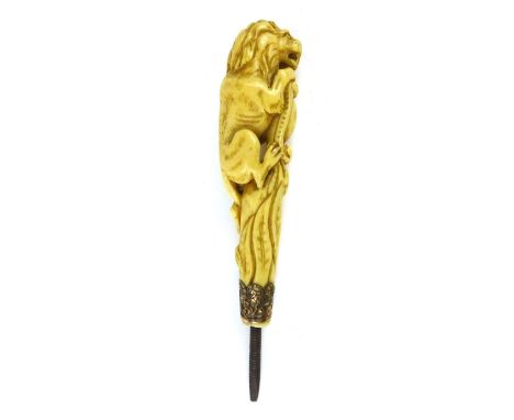 A Victorian ivory parasol or walking stick handle, well carved as a lion climbing on top of a shield, supported on pierced go