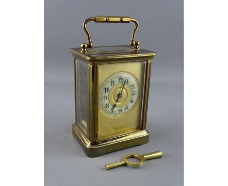 A FRENCH BRASS CASED CARRIAGE CLOCK, the enamel dial set with Arabic numerals, 14 cms high handle up, with key
