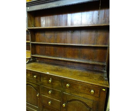 AN EARLY 19th CENTURY CAERNARFONSHIRE OAK DRESSER having a three shelf rack over a base having four centre opening drawers an