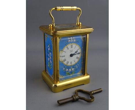 A HALCYON DAYS MINIATURE CARRIAGE CLOCK having blue enamelled side panels and mask around a circular white dial set with Roma