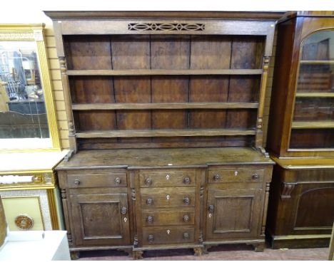 A MID 19th CENTURY OAK WELSH DRESSER having a three shelf rack with turned end pillars and fretwork hood over a breakfront ba