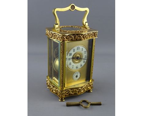 A GOOD 20th CENTURY FRENCH PIERCED GILT BRASS CARRIAGE ALARM CLOCK having a circular enamel dial and subsidiary alarm before 