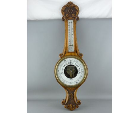 A CARVED OAK BANJO WALL BAROMETER with thermometer, 82 cms long