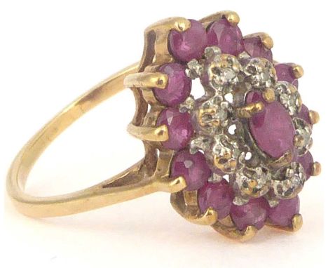 A 9ct gold ruby and white stone cluster ring, the central claw set marquise cut ruby surrounded by a border of eight tiny whi