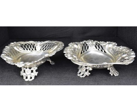 A pair of Victorian hallmarked silver heart-shaped dishes with pierced scroll sides, raised on three floral bracket feet, Wil