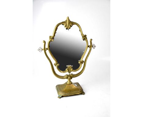 An Edwardian-style brass swing mirror with shell finial to the top, to square stepped base and four outswept supports, height