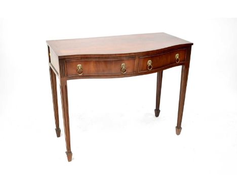 A mahogany reproduction side table with bow front and two drawers with lion mask hoop handles, on square tapered supports, 77