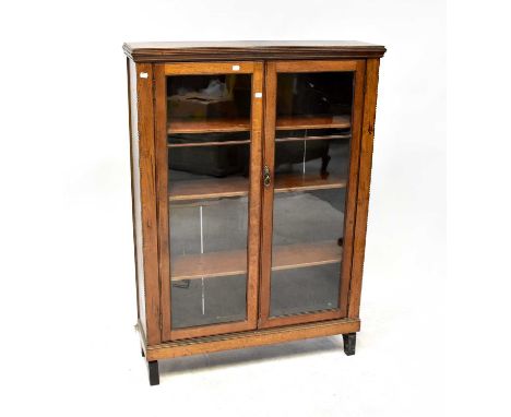 An early 20th century oak twin glazed door bookcase with three interior shelves, to plinth and block supports, 124 x 97 x 27c