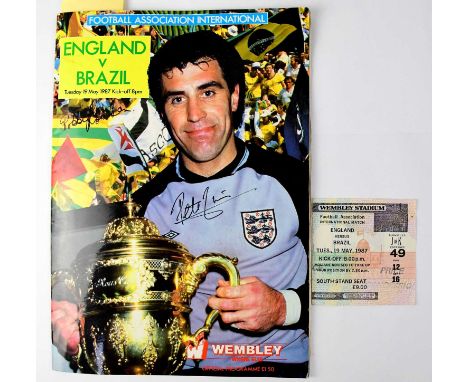 An England v Brazil 1987 programme bearing the signatures of Peter Shilton, Bobby Robson, Glen Hoddle, David Seaman, etc, wit