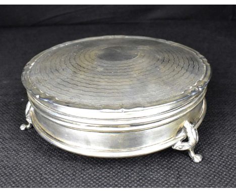 A George V hallmarked silver circular box with engine turned lid, cylindrical body, raised on three pad feet, Synyer &amp; Be